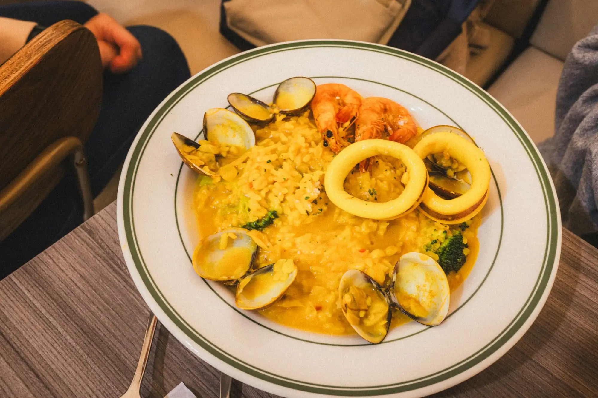 Arroz con mariscos meloso con conchas, langostinos y aros de calamar en un plato hondo