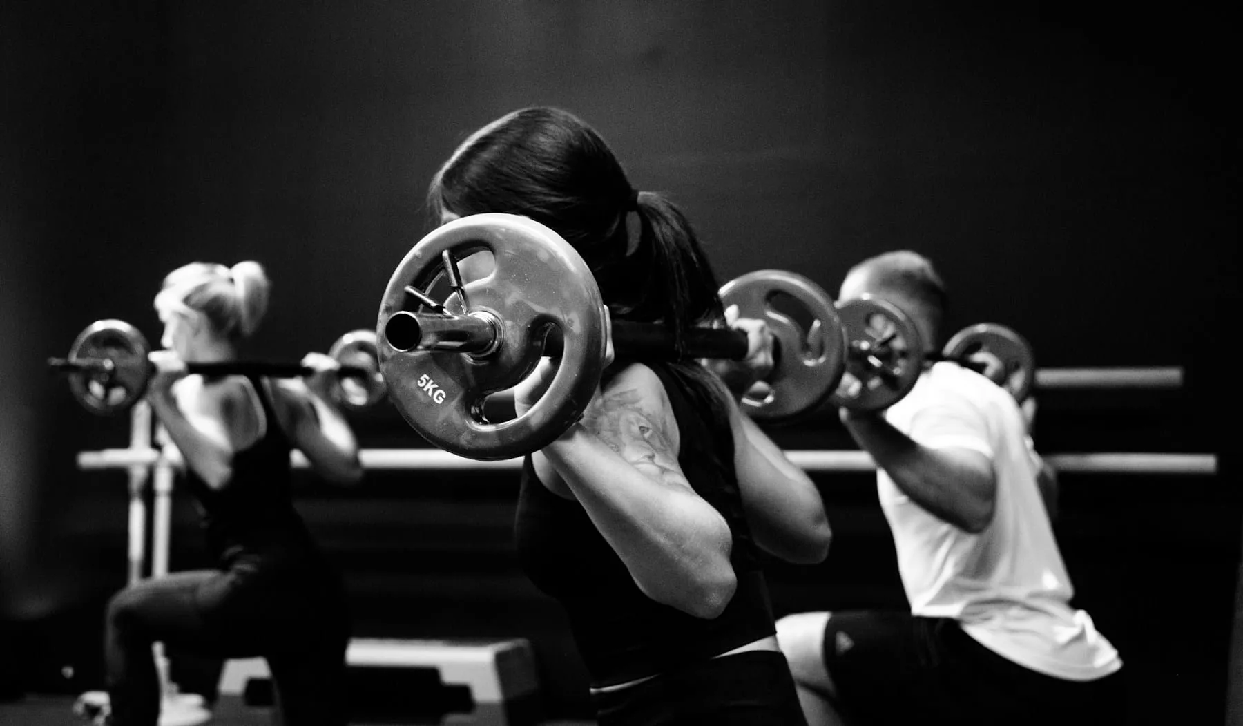 Entrenamiento con barras en grupo, en blanco y negro