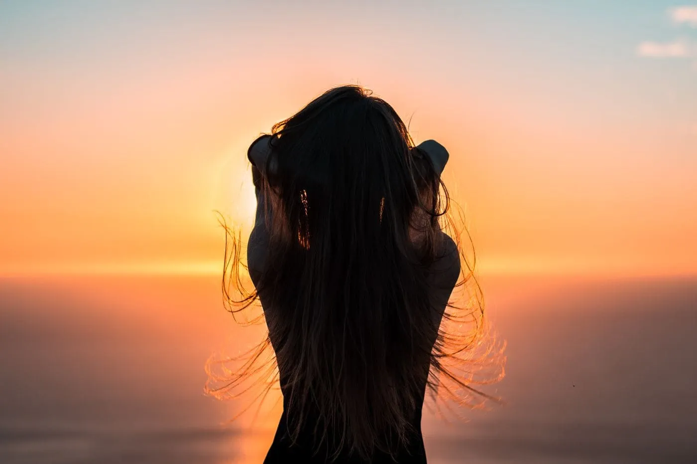 Melena oscura a contraluz al atardecer
